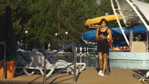 Menina bonita morena andando perto da piscina — Vídeo de Stock