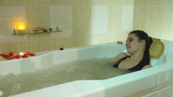 Młoda, piękna kobieta, leżąc w wannie z hydromasażem — Wideo stockowe