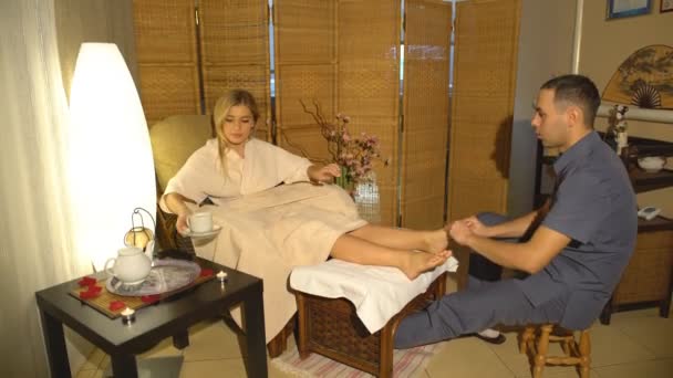 Vacker blond tjej gör fotmassage. Terapeutisk massage. — Stockvideo