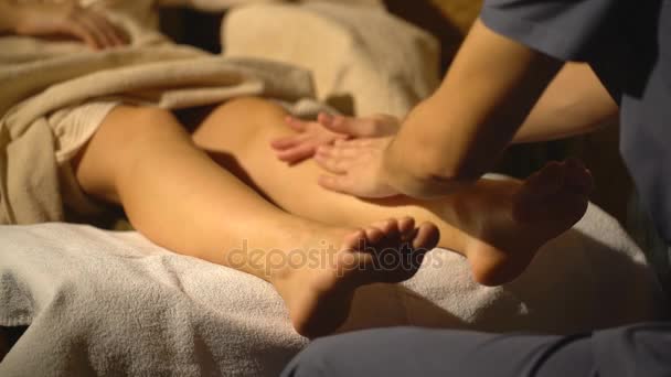 Beautiful blonde girl doing foot massage. Therapeutic massage. — Stock Video