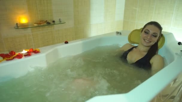 Giovane bella donna sdraiata nella vasca idromassaggio — Video Stock