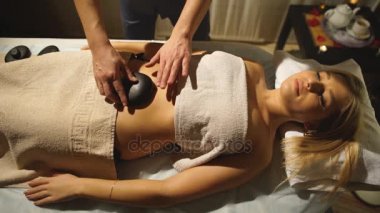 kadın bir spa merkezinde masaj sıcak taş alma