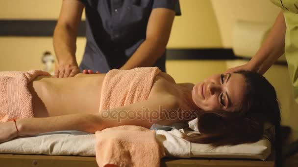 Chica en el procedimiento de masaje de cuatro manos en el salón de spa — Vídeos de Stock