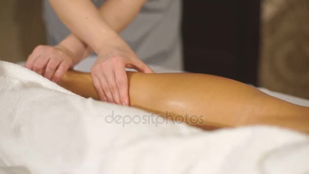 Женщина, делающая терапевтический массаж теленка — стоковое видео