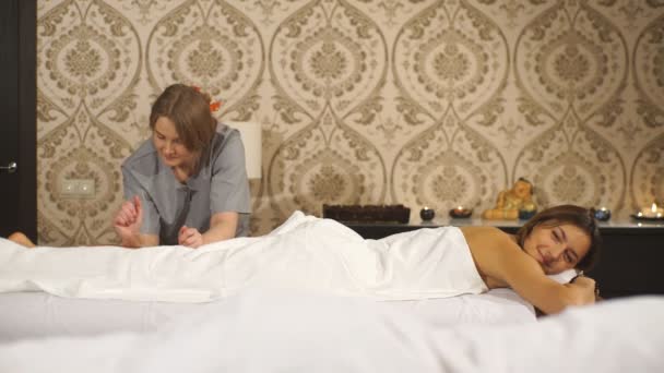 Опытный массажист, делающий молодой женский массаж телят — стоковое видео