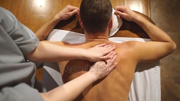 Skytte från ovan. man gör en axel- och ryggmassage, avkopplande, avkoppling — Stockvideo