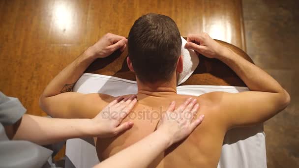 Disparando desde arriba. hombre haciendo un masaje de hombro y espalda, relajante, relajación — Vídeo de stock