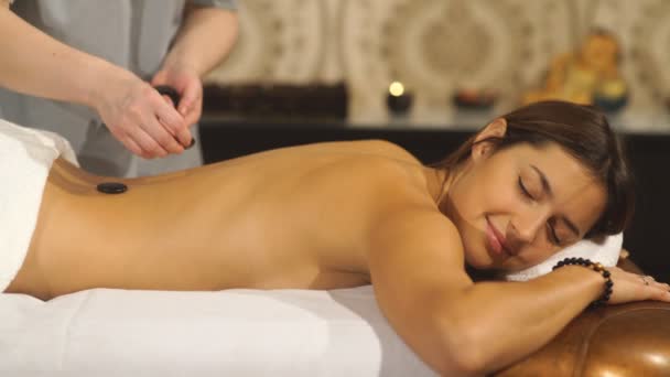 Chica en una terapia de piedra, masaje de piedra caliente — Vídeos de Stock
