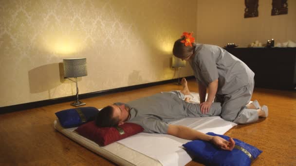 Ein Mann und eine Frau perfoming thai massage — Stockvideo