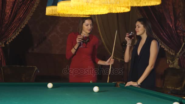 Mooie vrouw in rode avondjurk pool spelen — Stockvideo