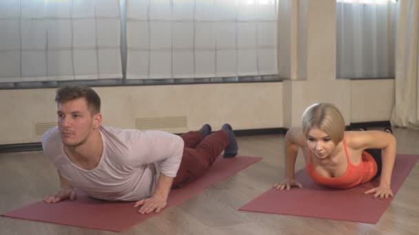 Mujer joven y hombre haciendo ejercicio de yoga Cobra — Vídeos de Stock