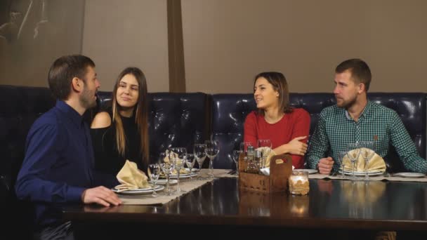 Két párok élvezi étkezés étteremben együtt — Stock videók