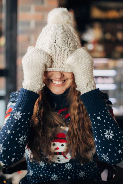 Vacker flicka i tröja med snögubbar drog en mössa över ögonen — Stockfoto