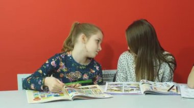 İki güzel arkadaş defterini bir şey dersi tartışıyor