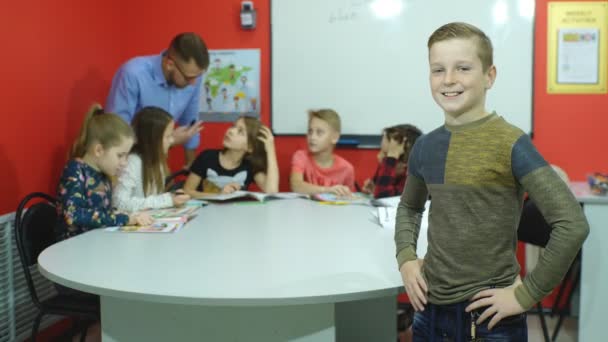 Kızıl saçlı okullu çocuk gülümseyen bir okul yönetimi standları — Stok video