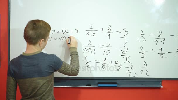 School jongen besluit voorbeelden wiskunde op schoolbord achtergrond, onderwijs examen concept — Stockvideo