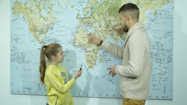 Schoolgirl showing countries on a map of the teacher — Stock Video