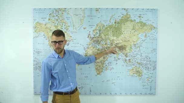 Jovem empresário com óculos mostra do país no mapa do mundo — Vídeo de Stock