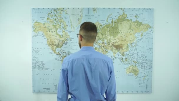 Un homme d'affaires regarde une carte du monde — Video