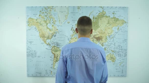 En affärsman ser ut på en karta över världen — Stockvideo