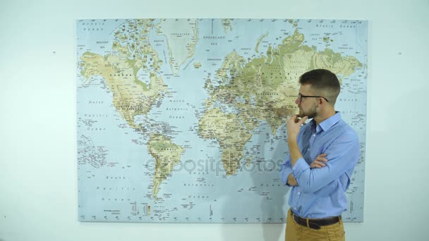 Jovem homem de negócios olhando para mapas do mundo — Vídeo de Stock