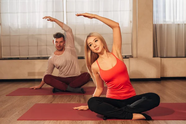 Erkek ve kadın yoga egzersizleri yapıyor