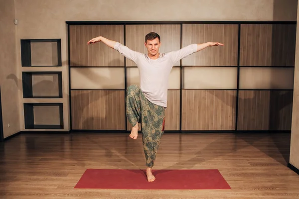 young strong man in the tree pose