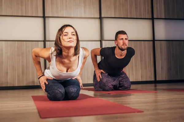 Jong koppel doen yoga oefeningen in fitnessclub — Stockfoto
