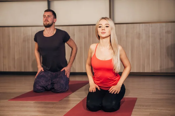 Jong koppel doen yoga oefeningen in fitnessclub — Stockfoto