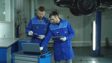 İki araba tam teşhis için hazırlanıyor mavi üniformalı makinist otomatik