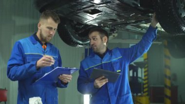 iki mekanik bir araba motoru ve not almak denetleme