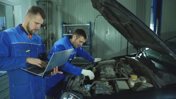 Meccanica con laptop in officina di riparazione auto — Video Stock