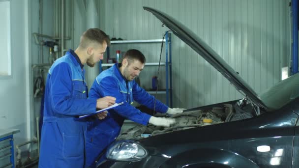 Dos mecánicos trabajando en un coche — Vídeos de Stock