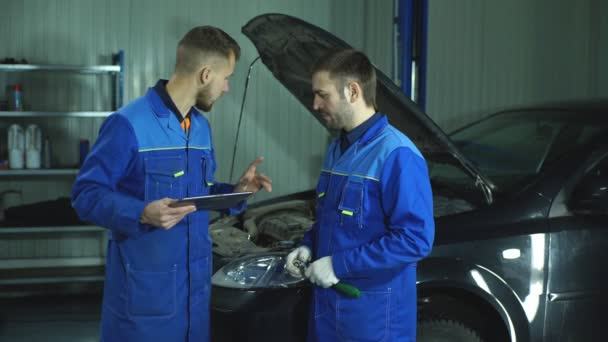 Dos mecánicos trabajando en un coche — Vídeos de Stock