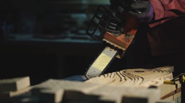 testere ile adam bir desen ahşap tahta üzerinde yapar.