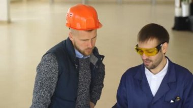 inşaat işçileri bir fabrikada iş yerinde portakal kask ile bir takım