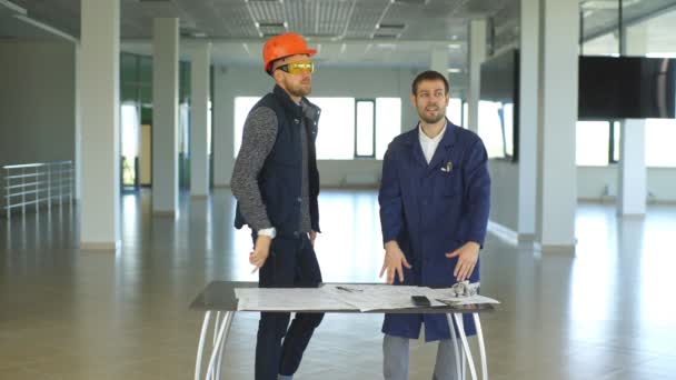 Architekt oder Ingenieur arbeitet an Bauplan und Architekturmodell in Halle — Stockvideo