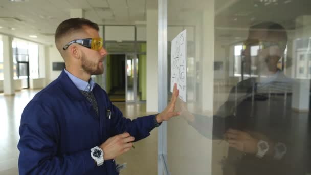 Arquiteto construtor estudando plano de layout das salas, engenheiro civil sério trabalhando com documentos no canteiro de obras — Vídeo de Stock