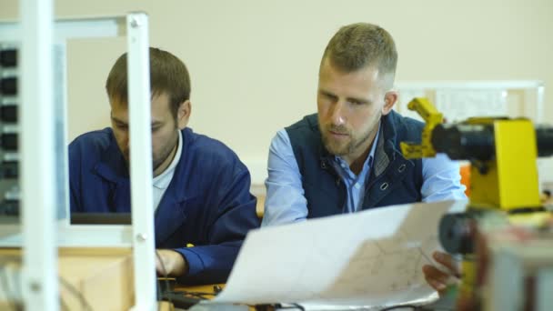 Dos jóvenes ingenieros trabajando juntos en un proyecto en el laboratorio de ciencias — Vídeo de stock