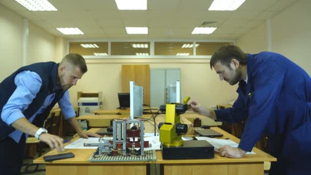 Dois jovens engenheiros trabalhando em um projeto juntos no laboratório de ciências — Vídeo de Stock