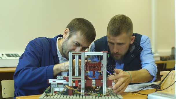 Dos jóvenes ingenieros trabajando juntos en un proyecto en el laboratorio de ciencias — Vídeo de stock