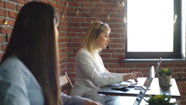 Zwei schöne Geschäftsfrau, die im Callcenter arbeitet — Stockvideo