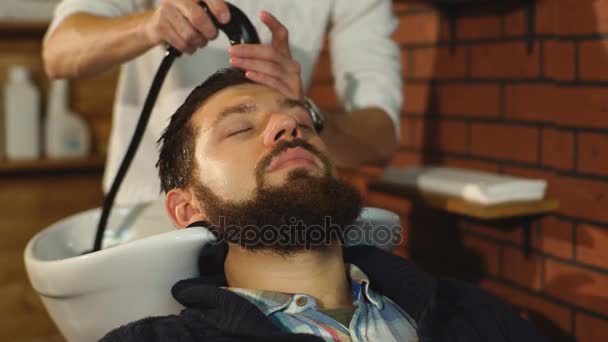 Berber dükkanında müşterilerin saçını yıkayan kuaför. — Stok video