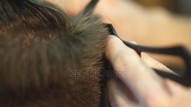 Mestre corta cabelo e barba de homens na barbearia, cabeleireiro faz penteado para um jovem — Vídeo de Stock