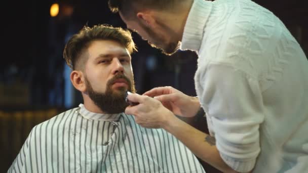 若いあごひげを生やした床屋で散髪を取得します。理髪店のテーマ — ストック動画