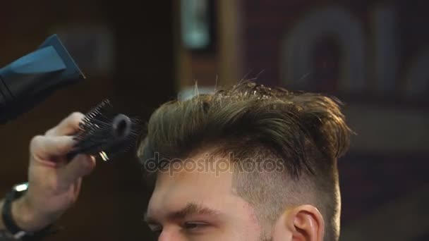 O barbeiro no processo de secagem de um cabelo clientes com um secador de cabelo no cabeleireiro — Vídeo de Stock