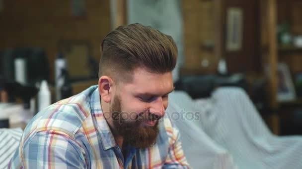 Homem feliz em óculos sorrindo em uma barbearia — Vídeo de Stock