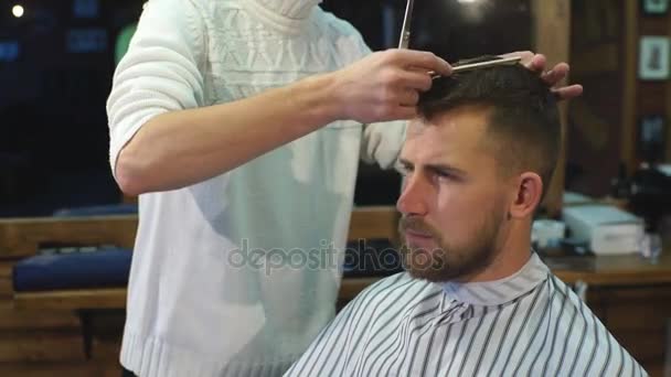 Cabeleireiro faz penteado um homem com barba — Vídeo de Stock