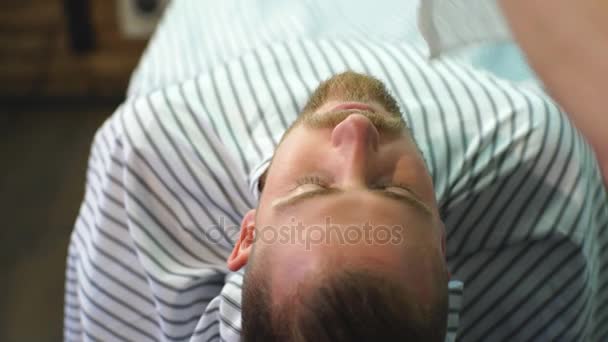 Kapper afwerking verzorgen en het verzorgen van cliënten gezicht in de barbershop — Stockvideo