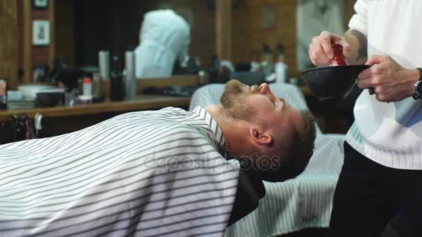 Szakállas ügyfél borotválkozás közben a borbélyüzletben — Stock videók